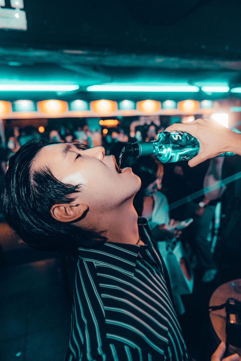 guest having fun drinking vodka straight from the bottle in a itaewon nightclub