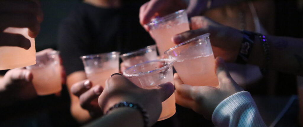 Friends raising their glasses on an SNL night