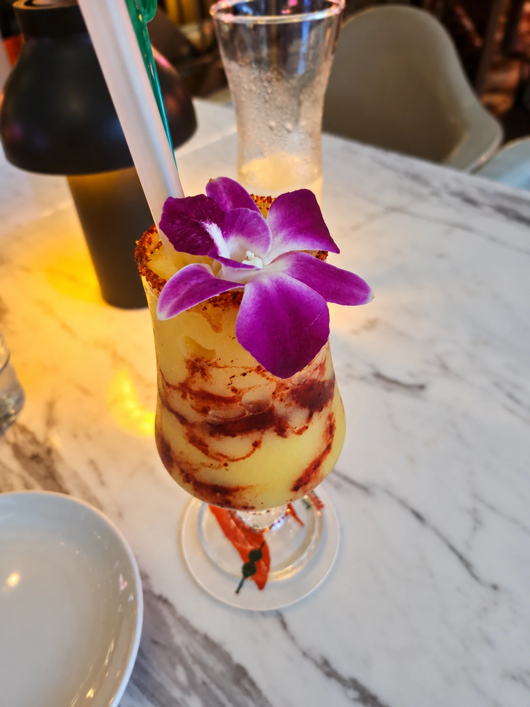 Mango Chamoy cocktail with a purple orchid at Bistro Mexi.