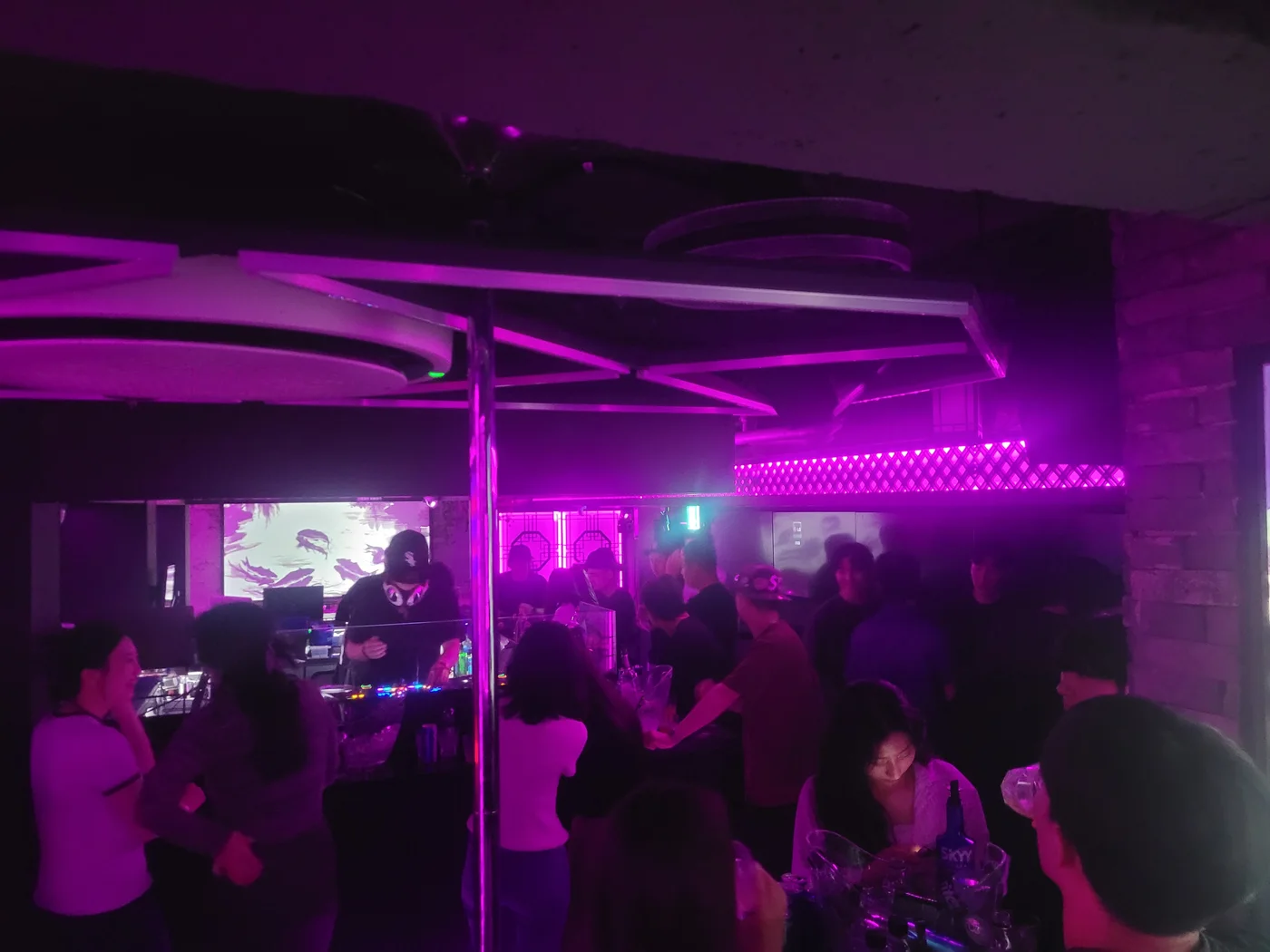 DJ and guests inside Pungwol under purple neon lighting