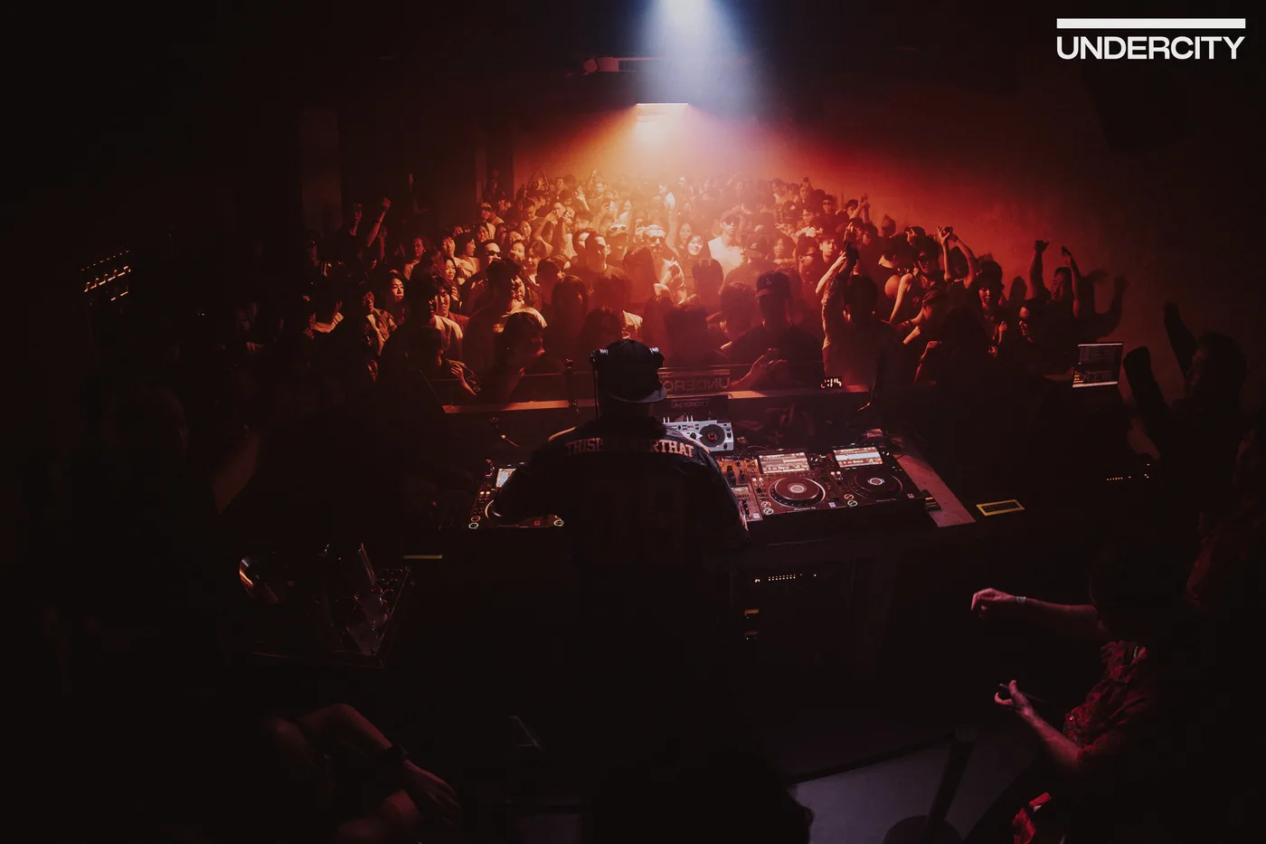 A DJ facing the crowd at UNDERCITY during a music event