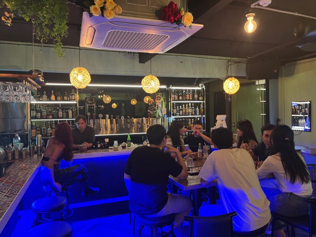 Guests chatting around the bar during a social evening at Taco Amigo
