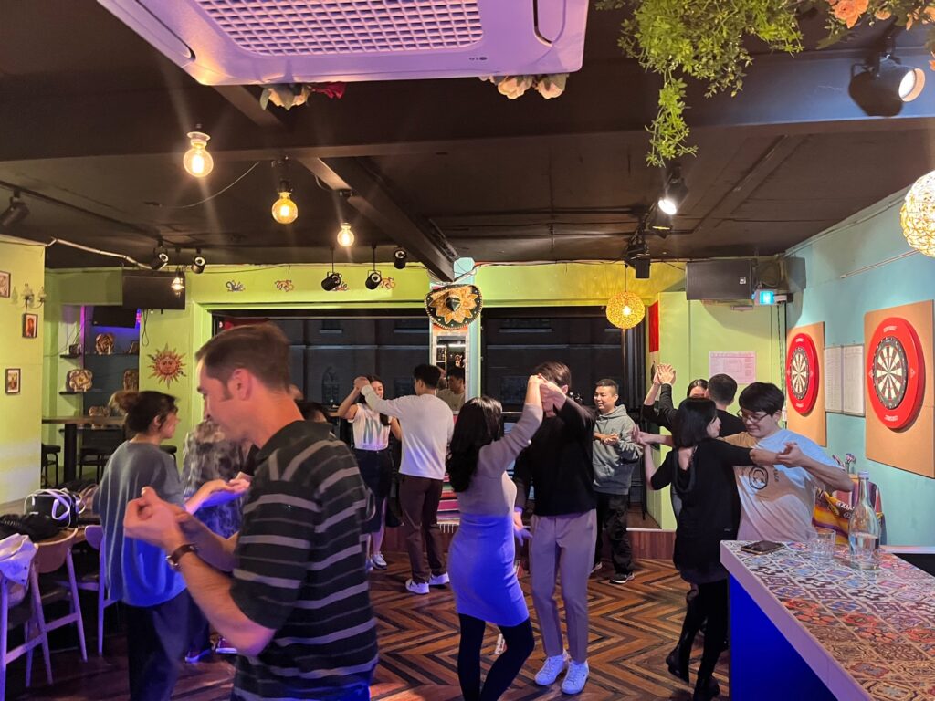 Pairs practising dance steps together in the Taco Amigo event room