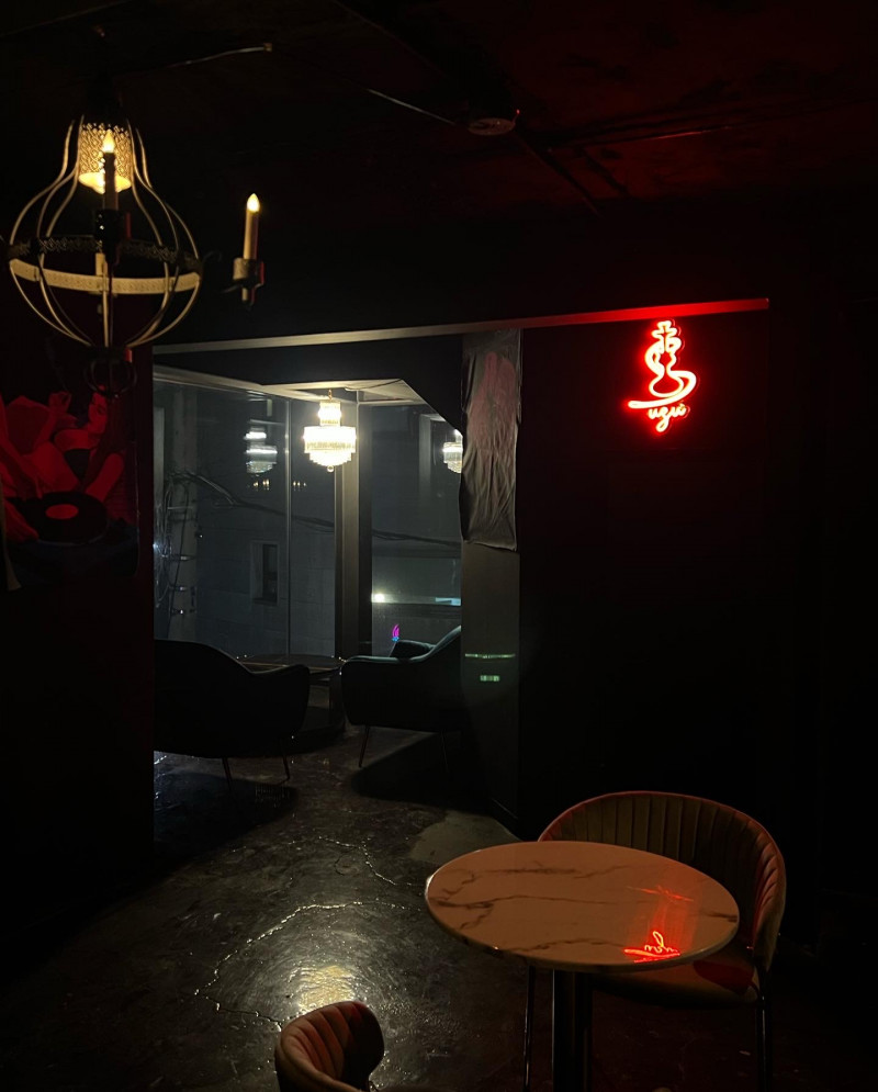 Lounge seating, tables and red UZU neon inside UZU Hongdae