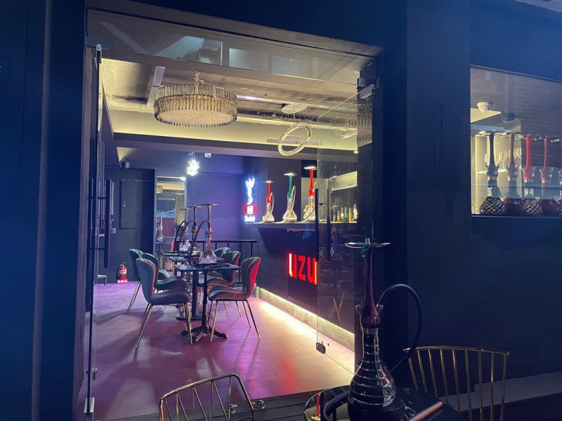 Tables, chandeliers and illuminated bar seen through the lounge at UZU Itaewon